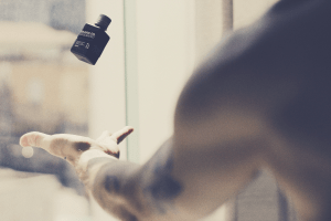 black man with beard oil container